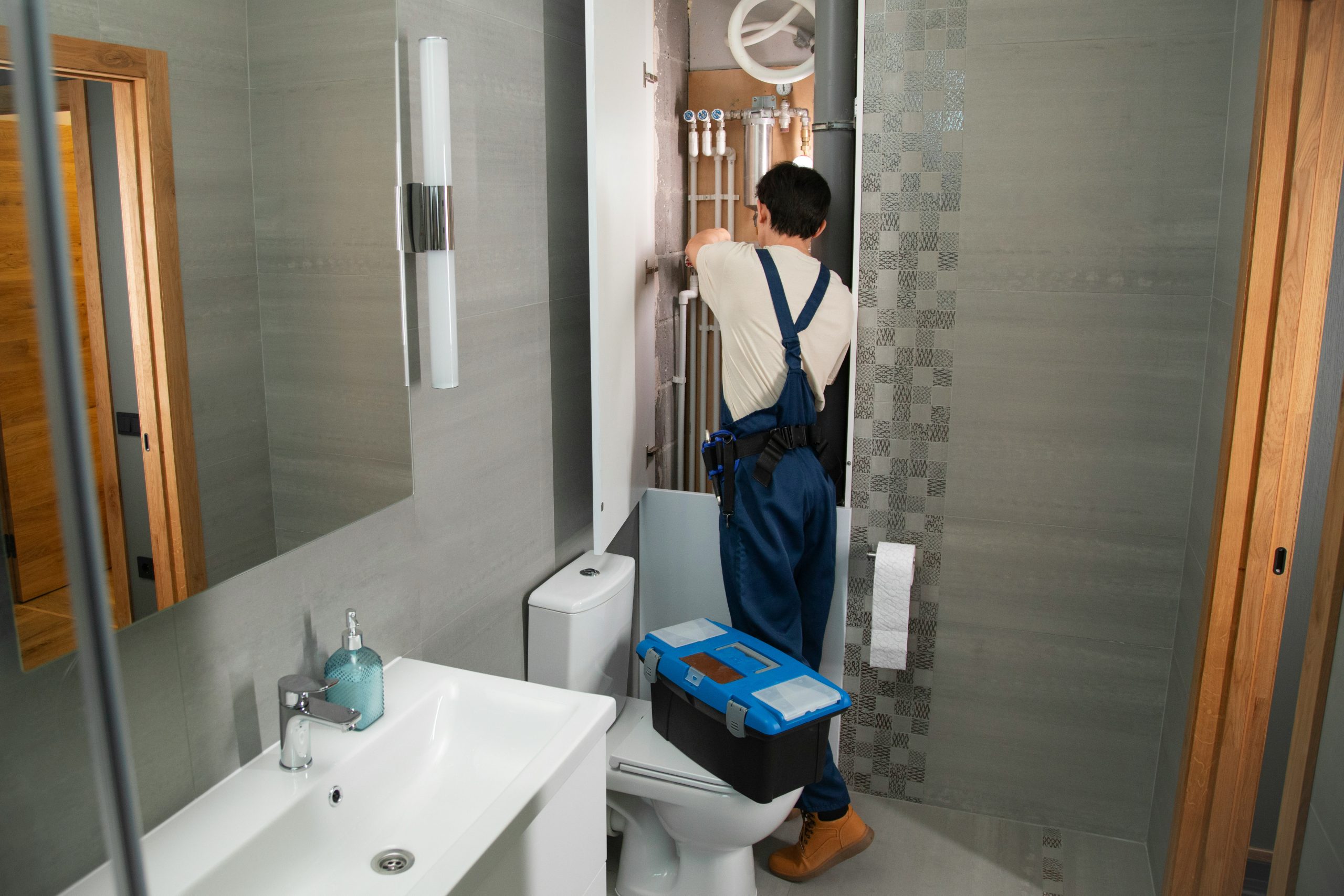 Plumber working on bathroom pipework